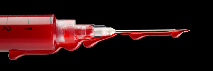 Syringe filled with blood and dripping from the needle - isolated on black