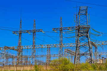 High voltage power lines towers on blue sky background