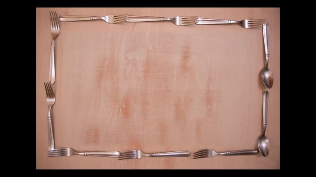 Stop motion top view of forks and spoons on wooden board, ideal for video transition or blogs