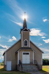 Suburst over the steeple of the historic Nordland Lutheran Church on the prairies near Stewart Valley, Saskatchewan, Canada