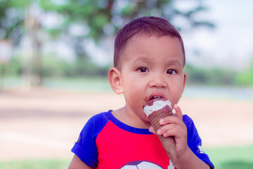 close up portriat asian cute little children eating ice-cream are happiness  and funny in park at thailand