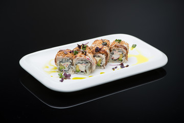 sushi in a plate on a black background with reflection. fish roll