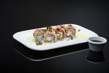 sushi in a plate on a black background with reflection. fish roll