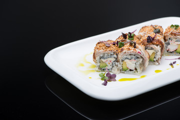 sushi in a plate on a black background with reflection. fish roll