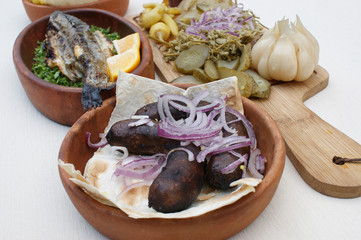 georgian food. grilled kupaty (sausage). in a ceramic bowl
