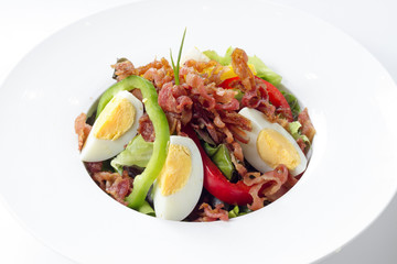 Fresh Caesar Salad with Deep-fried Bacon and Boiled Egg on White Porcelain Round Dish, on White Background with Shadow. Close Up High Angle Side View, Selective Focus at Food.