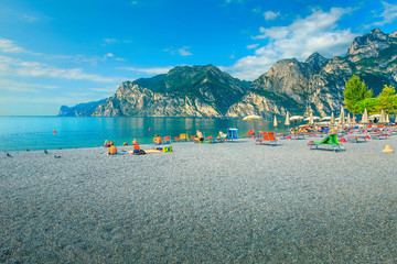 Fototapeta na wymiar Lake Garda with gravel beach and sun loungers, Italy, Europe