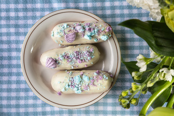 Tasty eclairs on wooden table, close up