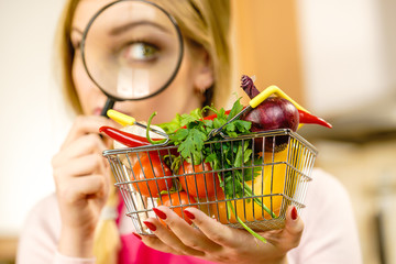 Woman investigating shopping backet with vegetables - obrazy, fototapety, plakaty