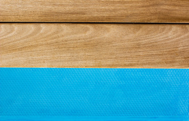 wooden deck floor and blue water swimming pool entrance stairs brown and blue colors simple background wallpaper pattern with textured surface and empty copy space for text or inscription