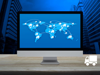 Delivery truck icon with connection line and world map on modern computer monitor screen on wooden table over office city tower and skyscraper, Business transportation online concept, Elements of this