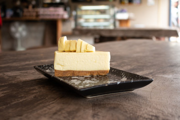 Cheesecake with topped Durian fruit and Durian cream on wooden desk background. Summer fruit for dessert in Thailand and Asia