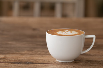 Piccolo Latte art in a cup topping beautiful heart art from milk on wooden table