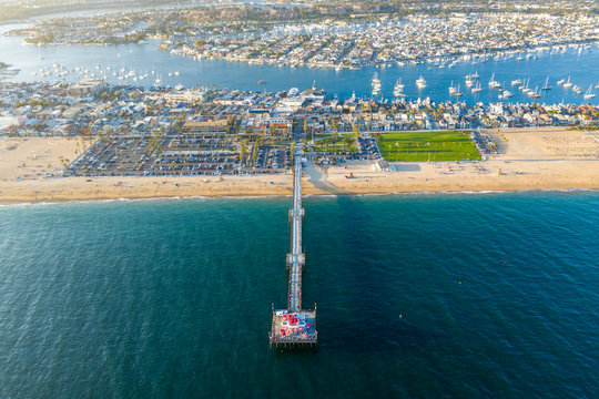 Fototapeta Aerial view from above over Newport Beach in coastal Orange County, California on a sunny day from above with the ocean, pier and harbor in view.