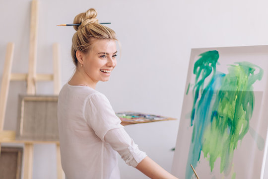 happy girl laughing at somebody while painting in the room with modern interior, happiness concept