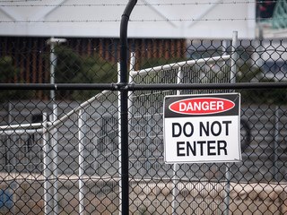 Warning sign of 'Danger Do Not Enter' on galvanised wire security mesh/fence.