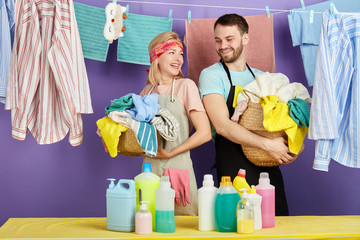 laughing smiling blonde woman and bearded man in stylish casual clothes having fun in the laundry room. close up portrait. isolated blue background. studio shot.happiness, emotion and feeling