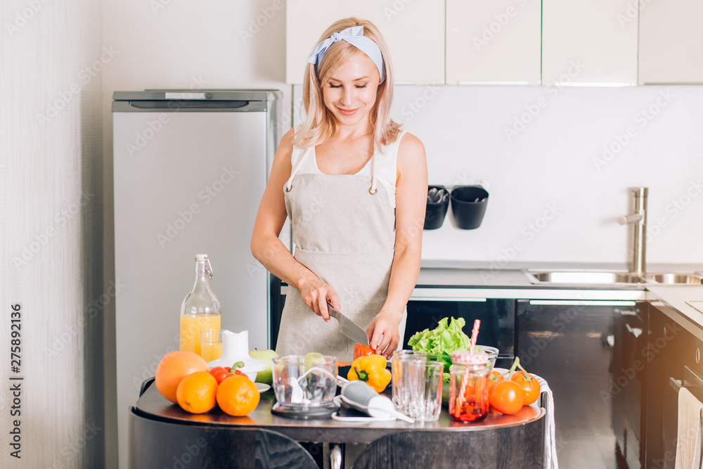 Wall mural young woman cooking in the kitchen