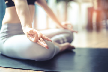 Young woman practicing yoga in  gray background.Young people do yoga indoor at home.