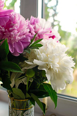 Pink and white peonies in vase with vintage look.