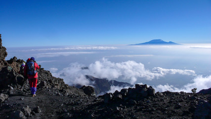 climbers hike down from the summit of Mount Meru in Arusha National Park in Tanzania