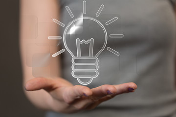  holding illuminated light bulb, idea, innovation and inspiration concept.
