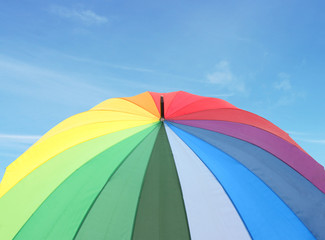 Rainbow umbrella on blue sky background