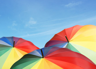 Rainbow umbrellas on blue sky background
