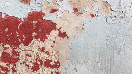Concrete wall with cracked paint as abstract background