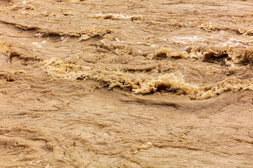 Dirty water runs in a mountain river