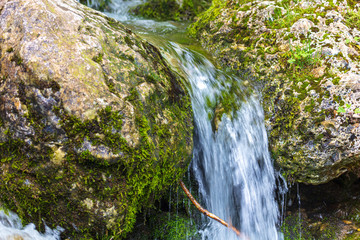 Water runs over rocks in the mountains