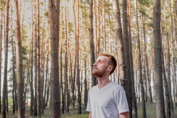 Young man enjoying the nature during a walk or jogging in the forest. Portrait of a male person...