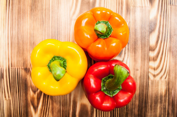 Colorful sweet pepper on wooden cutting board. Top view.