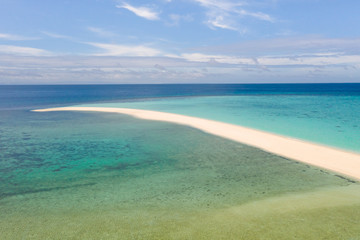 Fototapeta na wymiar Sand beach island on a coral reef, top view. Atoll with an island of white sand.