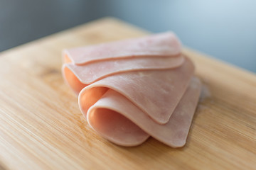 Sliced bacon on wooden background. Fresh prosciutto. Pork ham sliced.