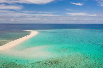 Sand beach island on a coral reef, top view. Atoll with an island of white sand.
