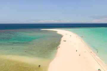Atoll with an island of white sand. Sand beach island on a coral reef, top view. Tourist route on Camiguin Island, Philippines.