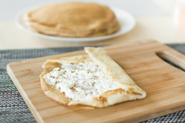 Traditional russian pancakes staffed with cottage cheese. Thin homemade pancakes with crispy crust. Maslenitsa holiday.