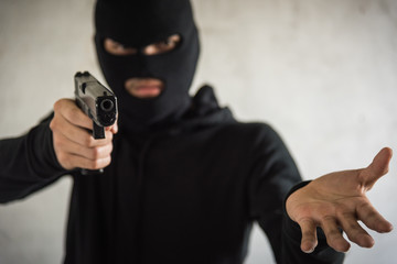 Robber with gun aiming into people