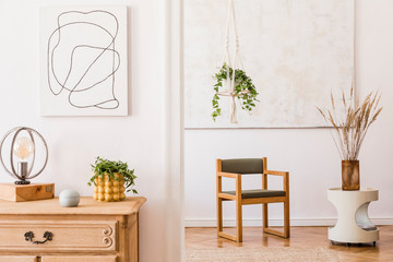 The modern boho interior of sitting room in cozy apartment with design armchair, white coffee table, plants, flowers, mock up poster and elegant personal accessories. Stylish home decor. Template.