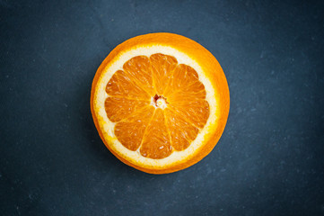 Slice of orange on a dark background. The concept of healthy organic nutrition. The power of superfood.