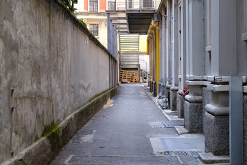 Strada industriale e vicolo di una via deserta sul dietro di una fabbrica ed azienda