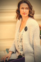 beautiful middle-aged woman in a blue knitted jacket with a brooch