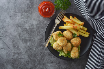 Chicken nuggets with french fried potatoes and ketchup, top view. Fast food.