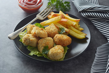 Chicken nuggets with french fried potatoes and ketchup, top view. Fast food.