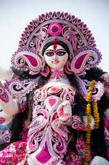 White and purple statue of Hindu goddess Saraswati being worshipped with flower in Kolkata , India.