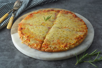 Hot cheeses delicious homemade pizza with thick crust on dark table, fast food.