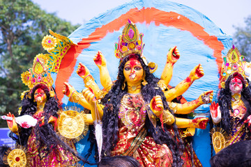 Fototapeta premium Golden and colorful statue of ten handed goddess Durga being worshiped with flower on the occasion of durga puja in Kolkata, India.