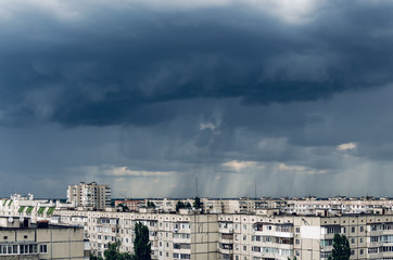 Dark storm clouds over houses, bad weather in the city