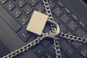 Cyber safety concept, locked chain on laptop computer keyboard